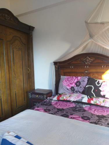 a bedroom with a bed with a wooden headboard at One Love Guesthouse & Restaurant in Luxor