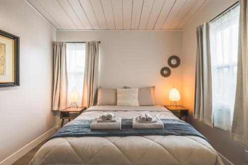 a bedroom with a bed with two towels on it at City Oasis - Entire Designer House - Near Disneyland in Hacienda Heights