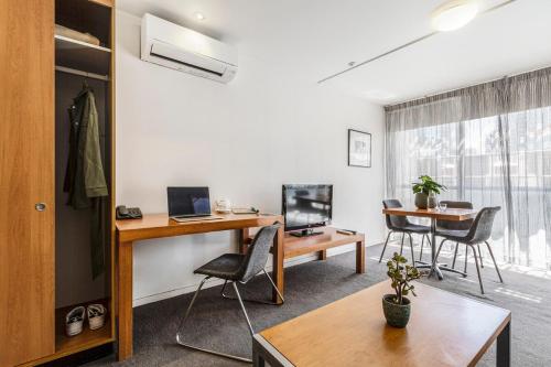 an office with a desk and a table with a computer at Punthill Apartment Hotel - Little Bourke in Melbourne
