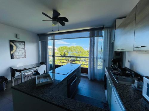 a kitchen with a ceiling fan and a large window at Coral suite vue sur mer in Arue
