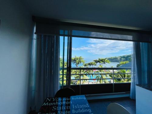 a room with a window with a view of the water at Coral suite vue sur mer in Arue