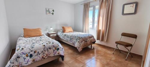 En eller flere senge i et værelse på Flores del Alma PSC