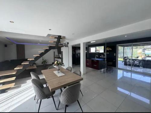 une salle à manger avec une table et des chaises et un escalier dans l'établissement Maison saint mars d outille, à Saint-Mars-dʼOutillé