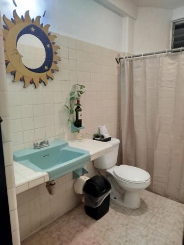 a bathroom with a toilet and a sink and a mirror at Hotel Coral in Cancún