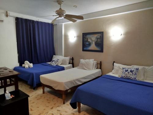 a bedroom with two beds and a ceiling fan at Hotel Coral in Cancún