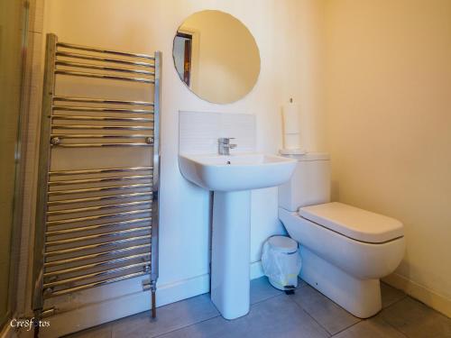 a bathroom with a sink and a toilet and a mirror at Wood House Executive Double Room 6 ensuite room in Stoke on Trent