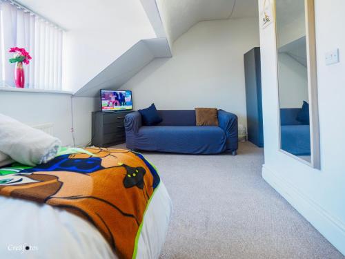 a room with a bed and a blue couch at Wood House Executive Double Room 6 ensuite room in Stoke on Trent