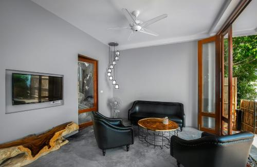a living room with a table and chairs and a tv at Philip's Villa in Koh Tao