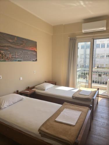 a hotel room with two beds and a window at Paloma in Athens