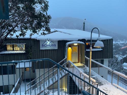a train is parked outside of a building in the snow at Schuss Alpine Club, Thredbo in Thredbo