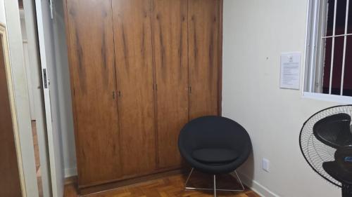 a room with a chair and a wooden door at Le house hostel in São Paulo