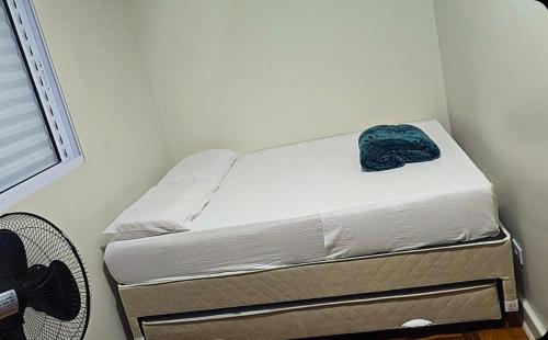 a small bedroom with a bed with a blue blanket on it at Le house hostel in São Paulo