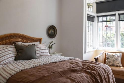 a bedroom with a bed and a clock on the wall at Poets Corner vintage retreat walk to View St in Bendigo
