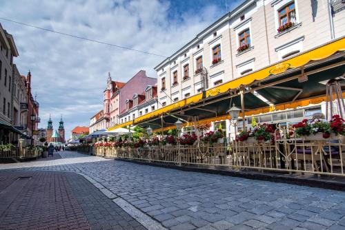 a street with flowerpots on the side of a building at Pietrak Hotel in Gniezno