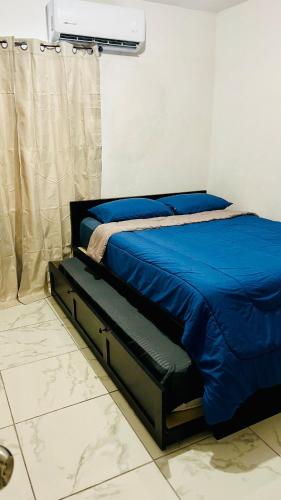 Un dormitorio con una cama con un edredón azul. en Relax Depa, en Matamoros