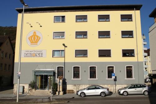 duży żółty budynek z samochodami zaparkowanymi przed nim w obiekcie Hotel & Restaurant Krone w mieście Geislingen an der Steige