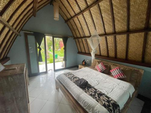 Un dormitorio con una cama grande con techo de madera. en Apit Lawang EcoLodge Nusa Penida, en Sampalan