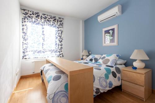 1 dormitorio con paredes azules y 1 cama con escritorio en StopinFlat, en Madrid
