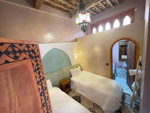a room with two beds and a mirror in it at Riad Dar Susan - Authentic Stay in Zagora in Zagora
