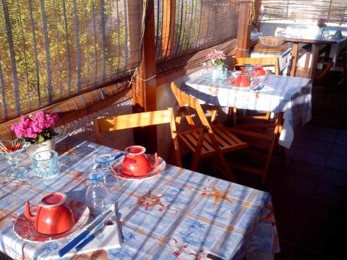 two tables with red tea pots on top of them at Bed and Breakfast La Reale in Stintino