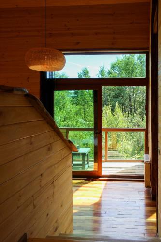 a staircase in a wooden house with a large window at NI-NEWEN Hotel & Lodge in Pucón
