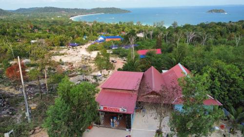 Sunrise View Hostel في Phumĭ Kâoh Rŏng: منظر علوي لمبنى به شاطئ وماء