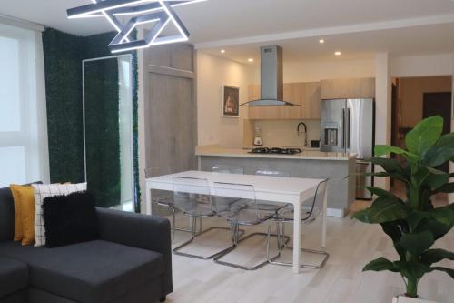 a kitchen and living room with a table and a couch at Romana Golf Suite in El Soco