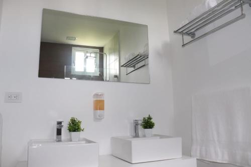 a bathroom with two white sinks and a mirror at Romana Golf Suite in El Soco