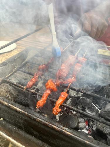 a bunch of food being grilled on a grill at Boochee Beach in Tampi