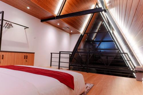 a bedroom with a large window and a bed at The Sikarim Waterfall View Villa in Kejajar