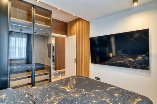 a bedroom with a bed and a tv on the wall at Luxury Suite Veselić in Valjevo
