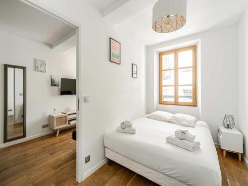 une chambre blanche avec un lit et un miroir dans l'établissement Cozy One bedroom apartment - Suquet Cannes, à Cannes