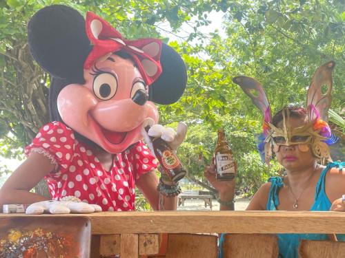 a woman standing next to a person in a mickey mouse costume at Boochee Beach in Tampi