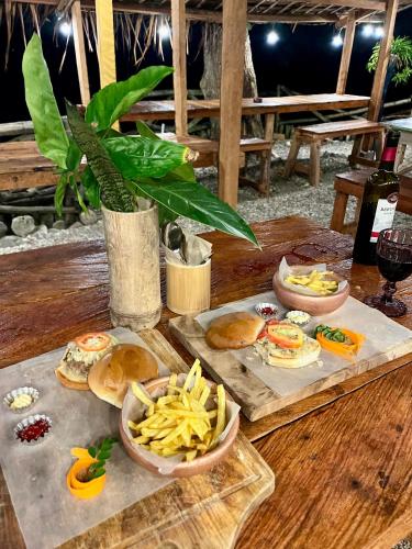 a wooden table with plates of food and snacks at Boochee Beach in Tampi