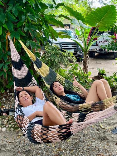 two women laying in hammocks in a garden at Boochee Beach in Tampi