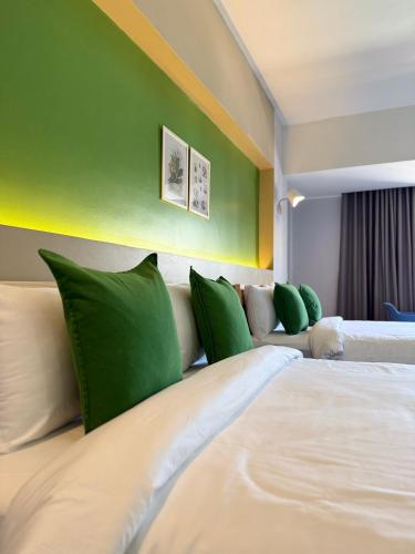 a hotel room with two beds with green walls at Chill Chill Hotel in Krabi