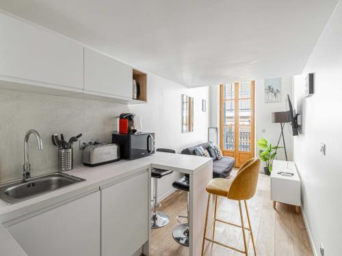 une cuisine blanche avec un évier et un micro-ondes dans l'établissement Bright duplex with a mezzanine - Cannes Center, à Cannes