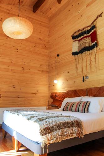 a bedroom with a bed in a wooden room at NI-NEWEN Hotel & Lodge in Pucón