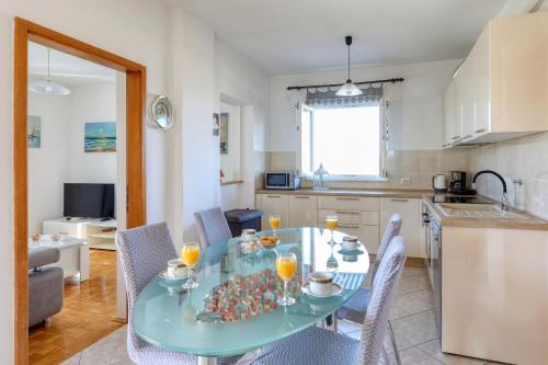 a kitchen with a table and chairs in a kitchen at Mediterranean Charm By Milena in Novigrad Dalmatia