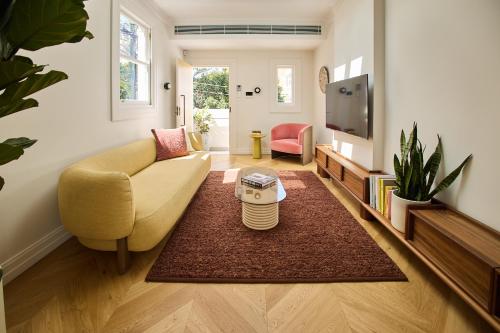 a living room with a couch and a tv at Flora Suite in Sydney