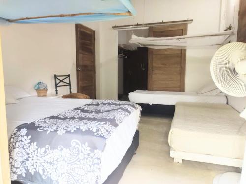 a bedroom with two beds and a fan at Habitación 4 personas in Moñitos