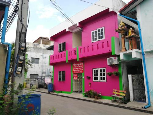 a pink building on the side of a street at Baan Busaya บ้านบุษยา in Ban Khlong Phutsa