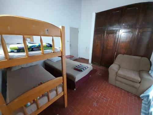 a bedroom with a bunk bed and a couch and a chair at Quintana in Asunción