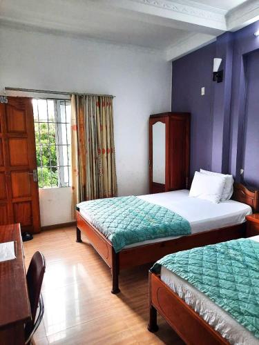 a hotel room with two beds and a window at Blue Sea Hotel 2 in Nha Trang