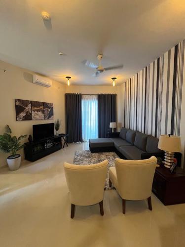 a living room with a couch and two chairs at Colombo, Trizen Luxury Apartments, Sri Lanka in Colombo