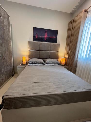 a bedroom with a large bed with a tv on the wall at Colombo, Trizen Luxury Apartments, Sri Lanka in Colombo