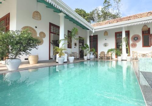 a swimming pool in front of a house at Marshmellow Surf Camp Sri Lanka in Ahangama