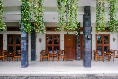 a restaurant with wooden doors and chairs and tables at Joglo Manggisan Syariah Kotagede Mitra RedDoorz in Yogyakarta