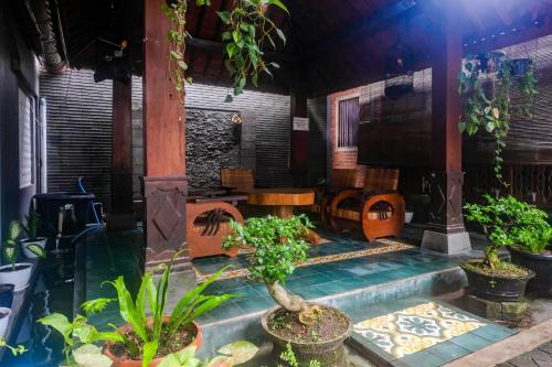a house with a pool with plants in it at Joglo Manggisan Syariah Kotagede Mitra RedDoorz in Yogyakarta