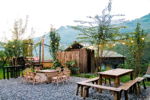 un patio con tavolo, sedie, tavolo e panche di A Phu Moutain House Sapa a Sa Pa